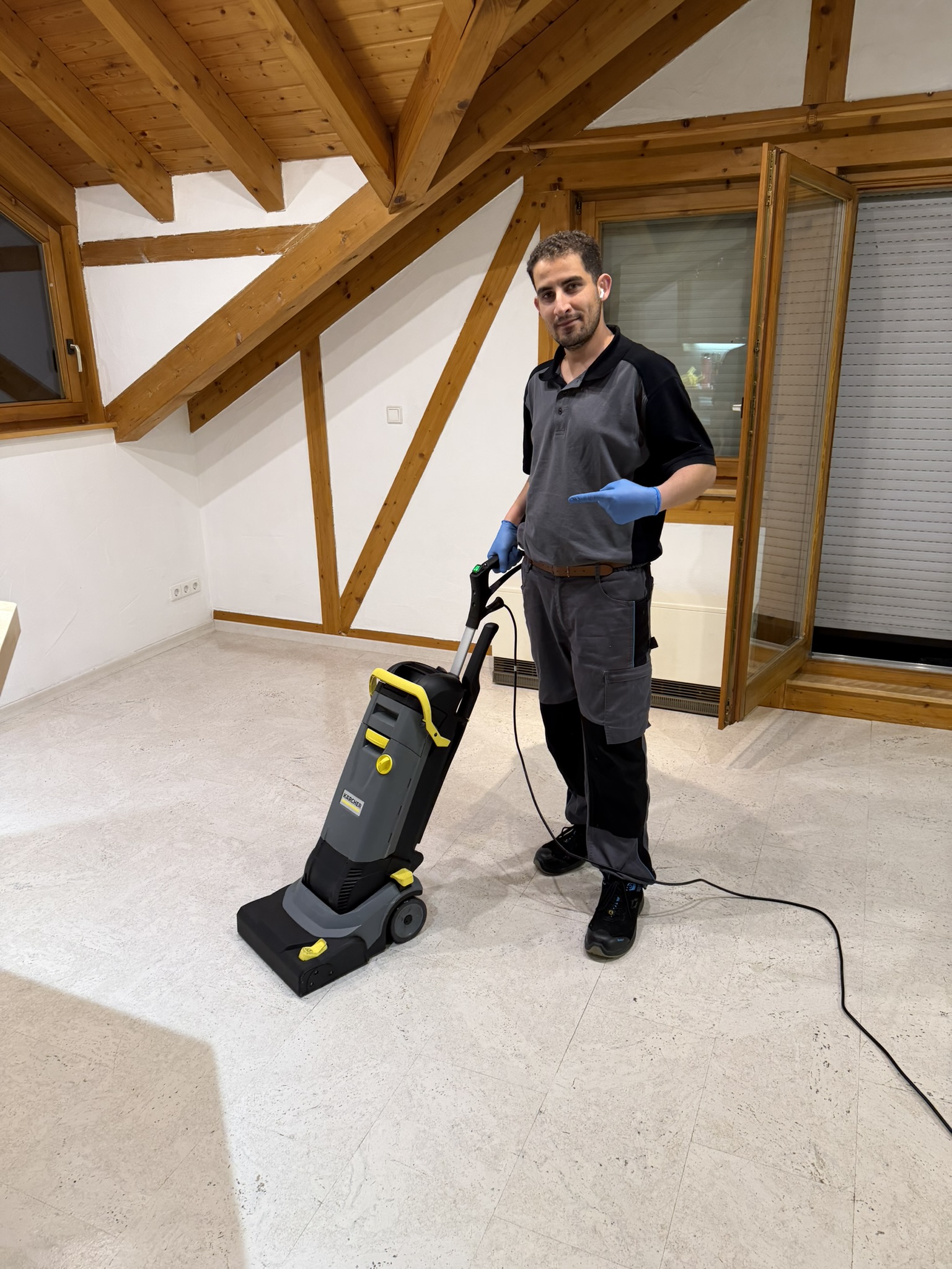 Mitarbeiter mit einer Scheuersaugmaschine in einer hellen Wohnung